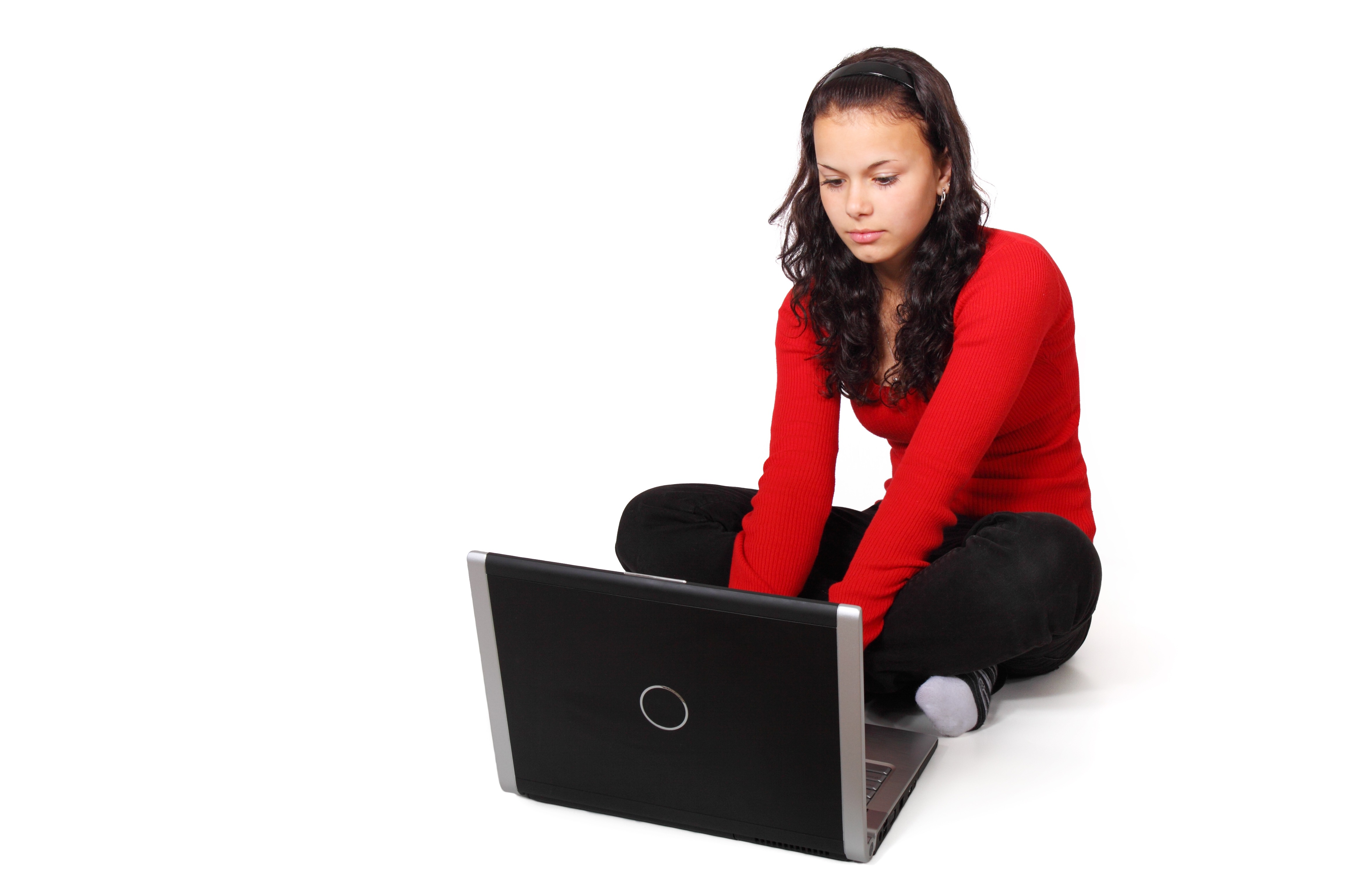Girl sits using laptop on floor, her hips rotated to the right and her shoulders counter-rotated left to face the screen